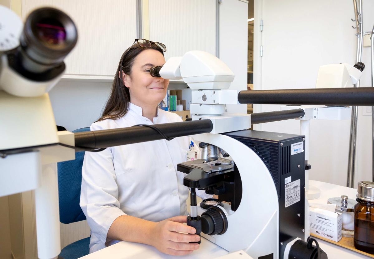 A doctor looking into a microscope.