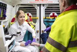 Ensihoitaja, potilas ja lääkäri ambulanssissa