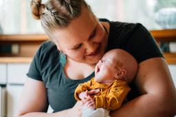 Pikkukeskonen Pyry haukottelee äitinsä sylissä.
