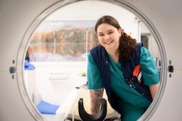 A radiographer looking trough an MRI machine. 